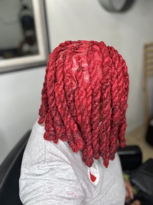 Hot red locs styled in a 2-strand twist bobb style