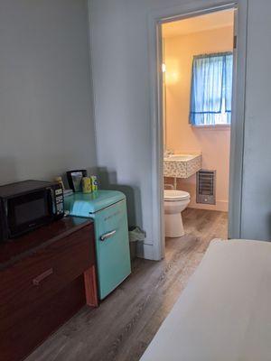 Looking towards bathroom with microwave and mini fridge (TV is to the left of microwave).