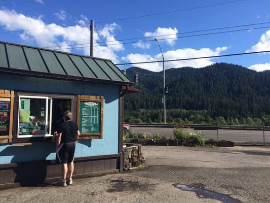 Cute blue espresso shop with forested mountains in the background