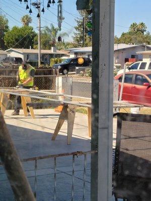 The men taking the old fence down.