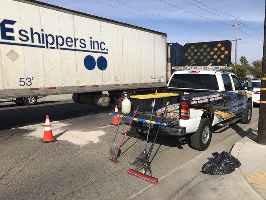 Cleaning oil from the roadway. Hazardous fluids can get into the storm drains if not remediated, causing the Kings River to be polluted