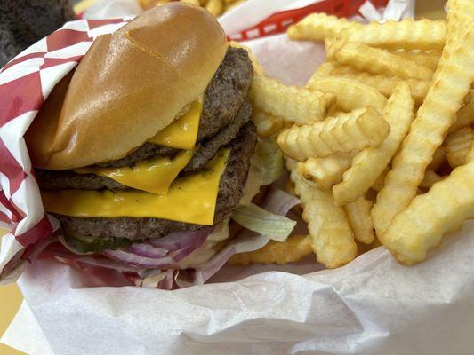 Triple patty cheeseburger with fries.