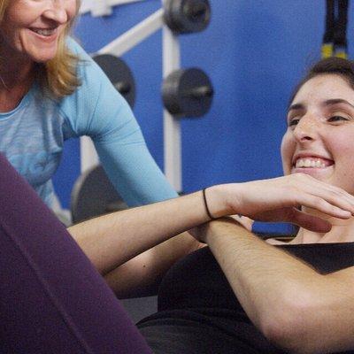 Personal Trainer Christy works with a client on the Bosu Ball