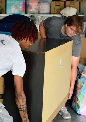 UniMovers gently placing a large furniture item in a moving truck.