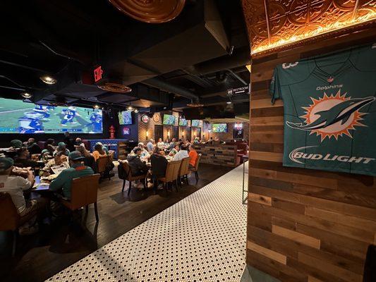 Dining area with a big screen and lot of nice TVs.