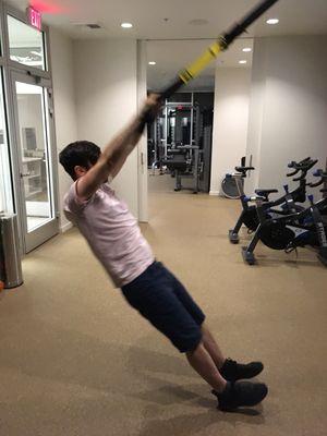 Jacob performing overhead back extensions on the TRX