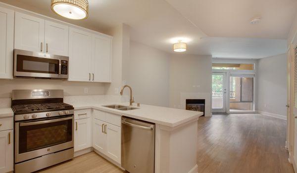 Modern kitchen features stainless steel appliances, granite countertops in select homes