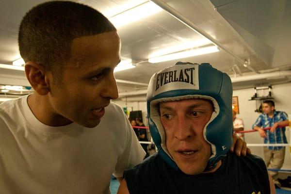 Boxing instructor Tarek H. gives some advice to fighter Lou B.