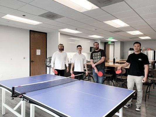 Friends and Colleagues enjoying a quick game of Ping Pong inside SureCo Break Room