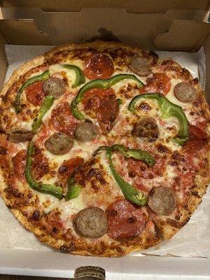 Pizza with sausage, pepperoni, pepper.