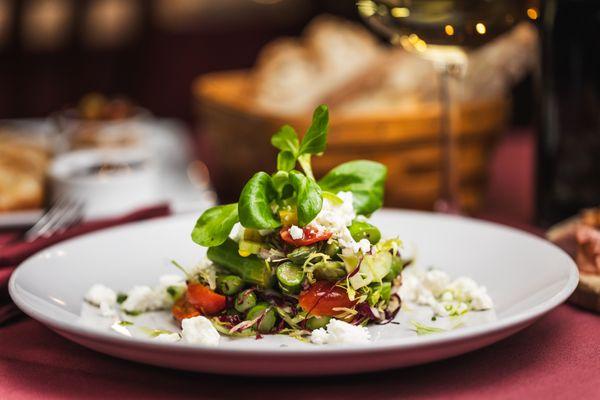 Asparagus Salad: A vibrant mix of goat cheese, fresh asparagus, tomatoes, and sweet corn in a zesty citrus dressing.