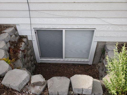 After new window installed and siding down beside a window before landscape project started