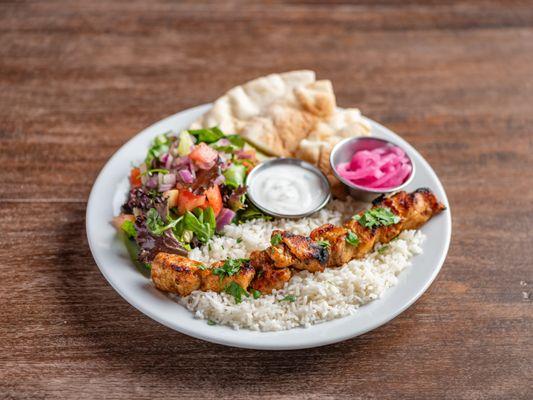 Chicken kebab plate with basmati rice, house salad, pita bread slices, your choice of in-house made sauce and pickled red onions.