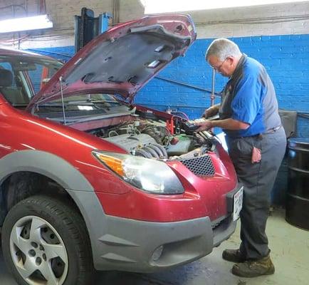 Martin Automotive mechanic using diagnostic equipment to fix car.