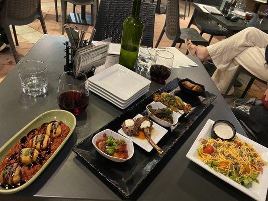 Goat cheese, meat sampler platter, salad, glass of wine.