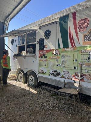 Food truck and they have a covered area with 6 tables