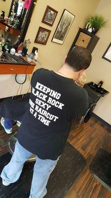 His shirt says Keeping Black Rock sexy one haircut at a time