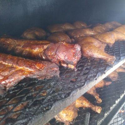 Chicken quarters and our baby back ribs picking up smoke from a clean burning fire of hickory and cherry.