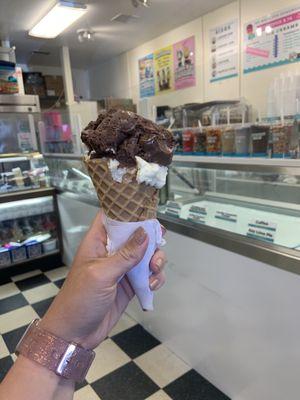 Waffle cone with one scoop of chocolate marshmallow and one scoop of cake batter ice cream