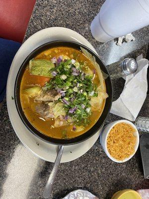 Caldo de res with beef potatoes corn on the cob carrots cabbage zucchini chickpeas  cilantro  diced raw jalapeño  limes  red onion diced.