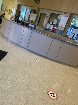 Empty front desk with a lobby full of ppl.