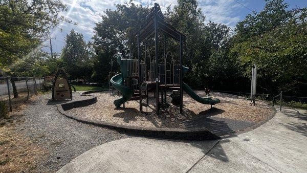 Nice playground that's quite large for the location along with a play house on the left