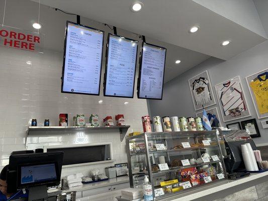 Menu, espresso machine, desserts from Central America, water with lemon slices.