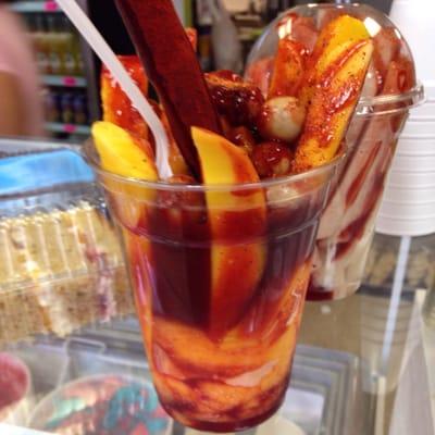 Mango sorbet. Mangos. Japanese peanuts. Tamarind candy pieces and straw. Chamoy sauce. Lime. Chili powder