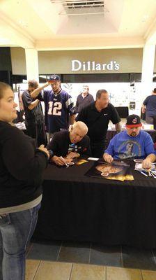 Wrestling Hall of Gamer Ric Flair signing autographs while P.A.A.S. does the witnessing and authentication.