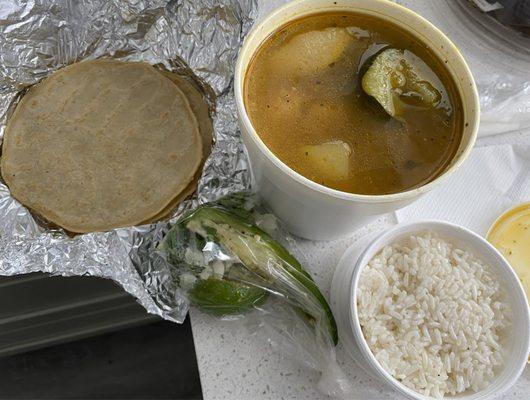 Caldo de gallina (hen soup) with rice and a plain pupusa (handmade Salvadorian-style tortilla).