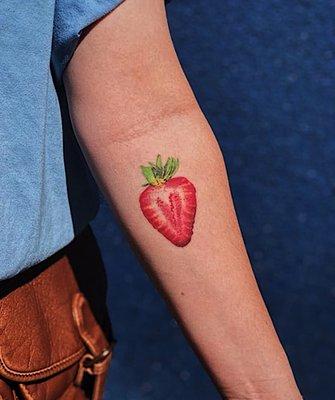 Fun colorful realistic and detailed strawberry tattoo done at shamanic ink tattoo shop