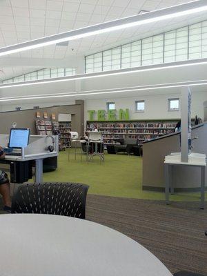 Teen area equipped with computers and comfy chairs.