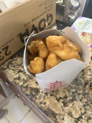 Chicken overflowing from container with either honey or sweet and sour on the side