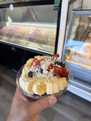 Açaí bowl topped with fruits, granola, and coconut