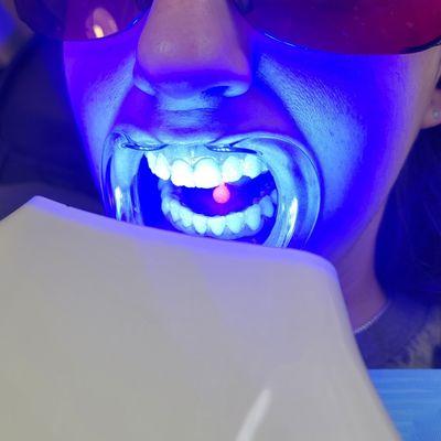 Client's tongue piercing glowing orange in the blue light