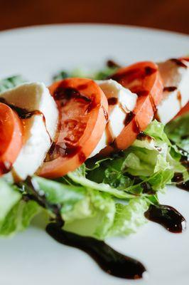 Capri Salad; fresh mozzarella, tomatoes, olive oil, and balsamic drizzle.