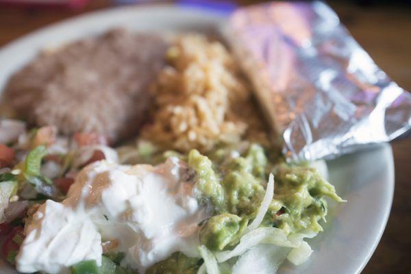 Fajitas come with sour cream, guac, homemade tortillas, pico de gallo, rice, and beans.