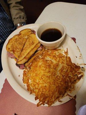 Prime rib sandwich with hashbrowns and au jus