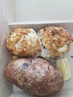 Crab cake entree with baked potato, coleslaw, roll and condiments