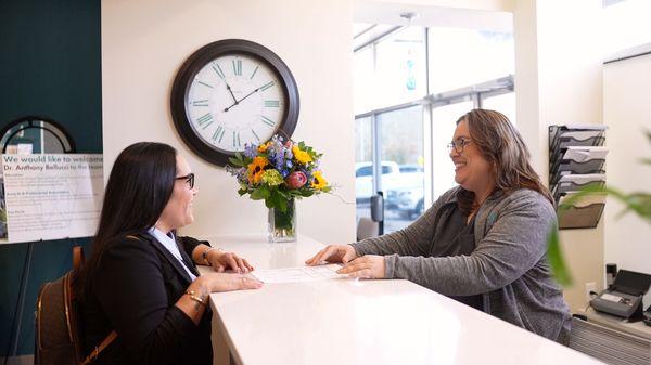 A patient checking out with a front desk team member.