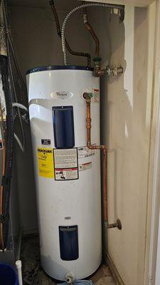 Leaking water heater without a drain pan and without a flood stopping device.