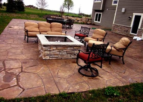 colored and stamped concrete patio with stone fire pit