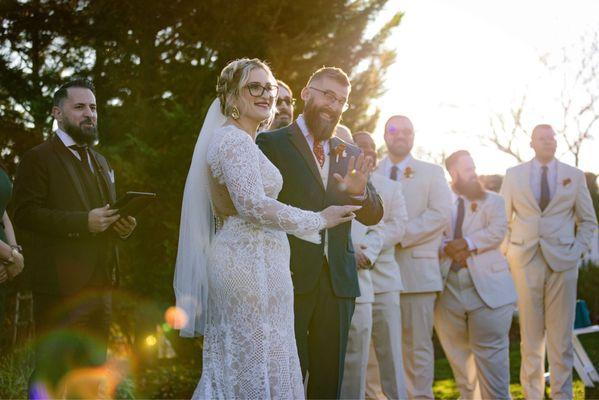 My husband and I with our pastors and groomsmen in background.