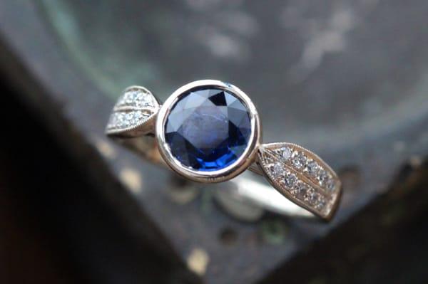 Stunning deep blue sapphire in a Leaf Band setting with tiny diamonds in 14K white gold.