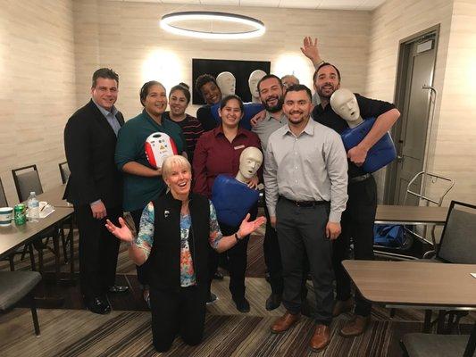 Our Instructor Debbie Nate with the GM and employees of The H Hotel celebrating finishing our First Aid, CPR/AED Course.