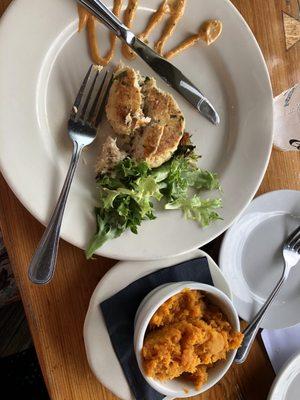 Crab cake, sauce on the side, greens with vinaigrette dressing and mashed butternut squash