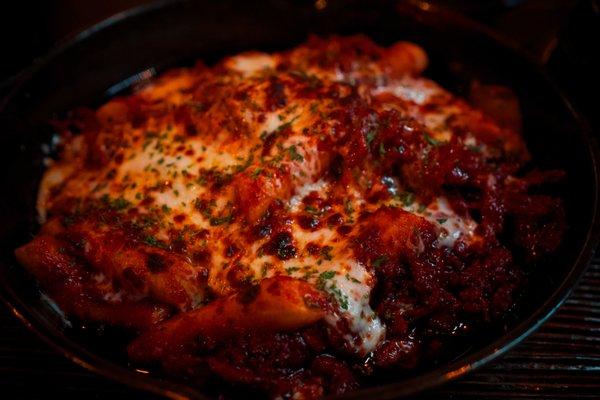 Closeup of rice cake with kimchi, pork, and mozzarella