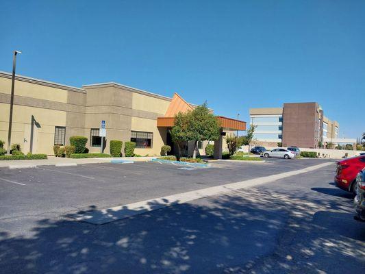 Front entrance, parking lot with handicap parking, and hotel next door.