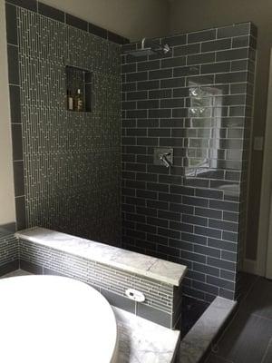 Modern glass tile and shower niche with wall mount rain shower head