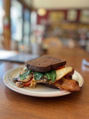 Custom breakfast sandwich. Spinach, tomato, egg over easy, mushrooms, onion! Oops...forgot the cheese! I did, not them!